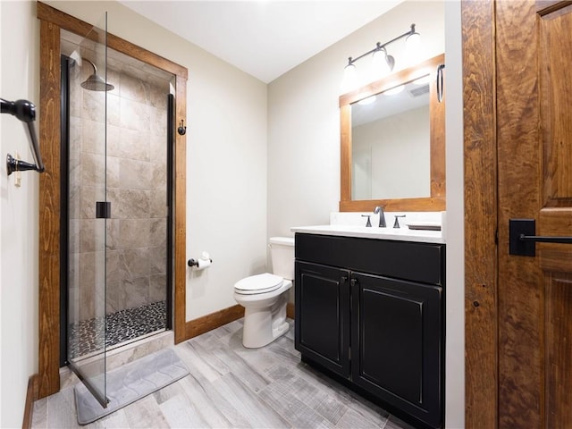 bathroom with vanity, hardwood / wood-style flooring, toilet, and a shower with shower door