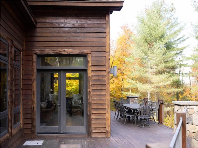 view of exterior entry featuring french doors and a wooden deck