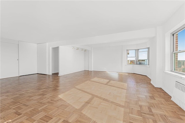 spare room featuring radiator and light parquet flooring