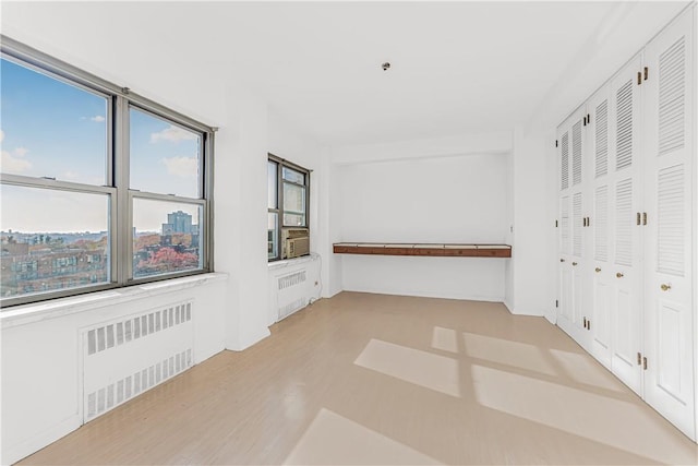 spare room with radiator heating unit and a wealth of natural light