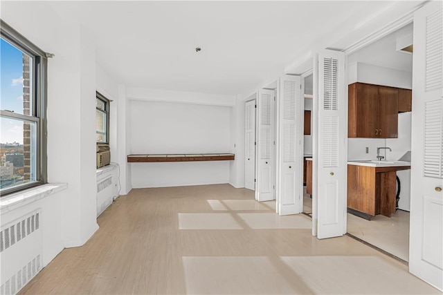 corridor featuring light hardwood / wood-style flooring and radiator