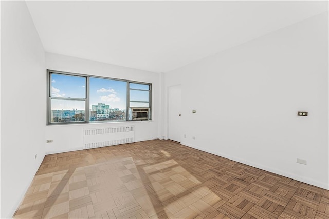 empty room featuring parquet flooring and radiator