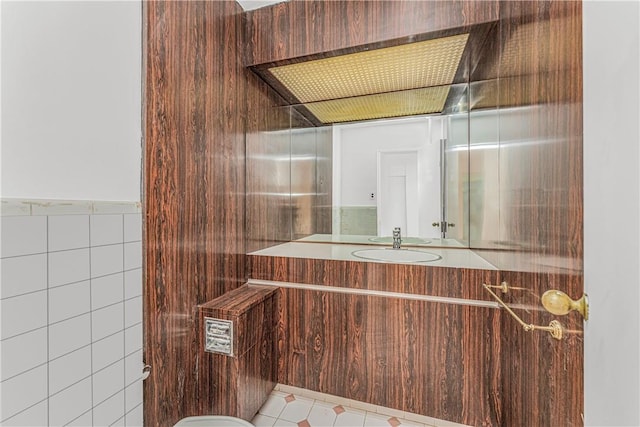 bathroom featuring tile patterned flooring, vanity, and tile walls