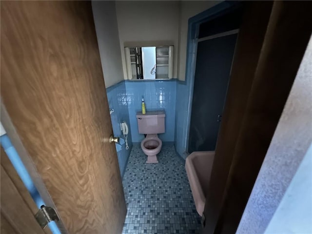 bathroom with tile walls and toilet