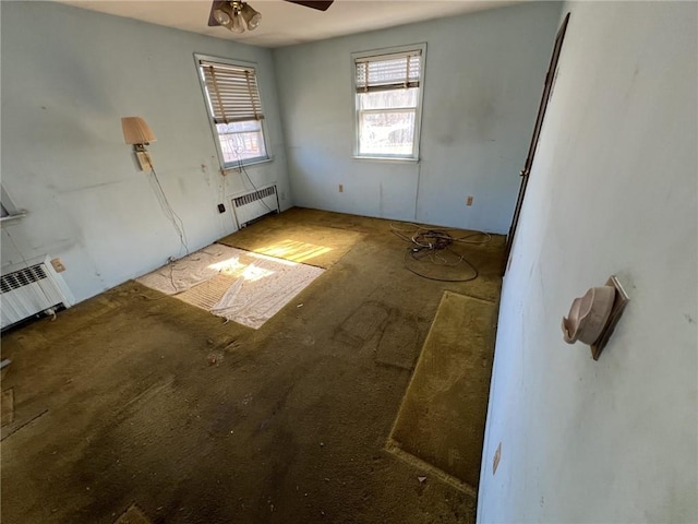 spare room with ceiling fan and radiator heating unit