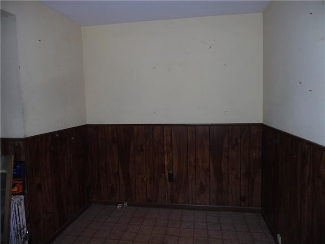 unfurnished room featuring wooden walls