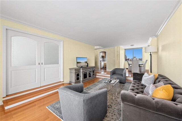 living room with light hardwood / wood-style floors and crown molding