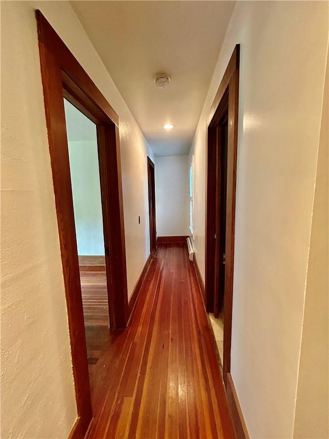 corridor with dark hardwood / wood-style flooring