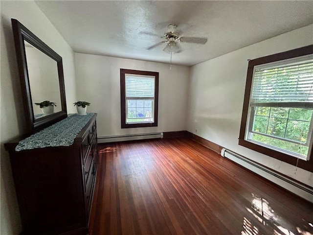 spare room featuring a textured ceiling, dark wood-type flooring, and a baseboard radiator