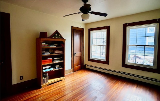 unfurnished bedroom featuring multiple windows, ceiling fan, light hardwood / wood-style flooring, and a baseboard radiator