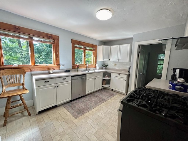 kitchen with gas stove, decorative backsplash, white cabinetry, and stainless steel dishwasher