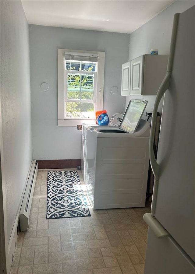 clothes washing area featuring cabinets, washing machine and dryer, and a baseboard heating unit