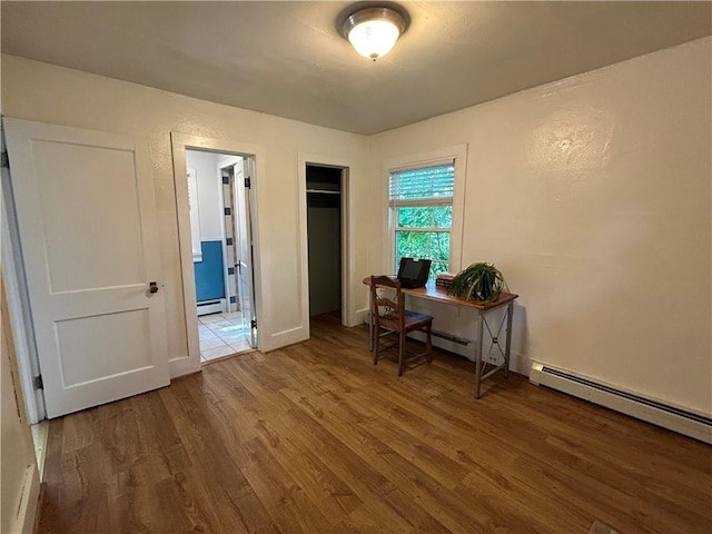 home office featuring wood-type flooring and a baseboard heating unit