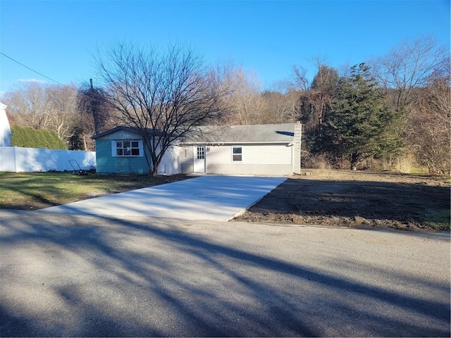 ranch-style house featuring fence and driveway