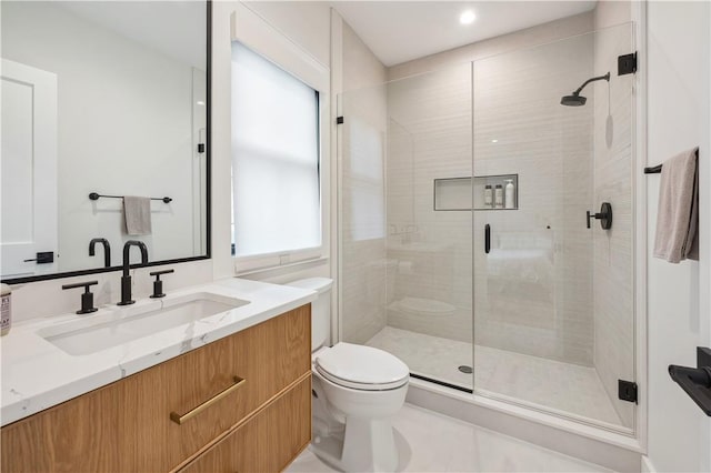 bathroom featuring tile patterned flooring, vanity, a shower with shower door, and toilet