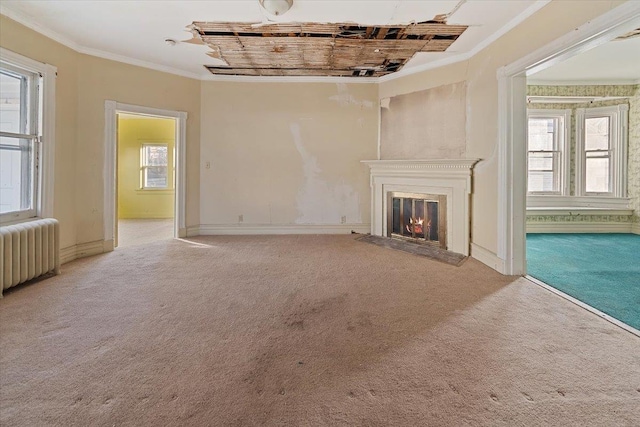 unfurnished living room featuring ornamental molding, light carpet, plenty of natural light, and radiator heating unit