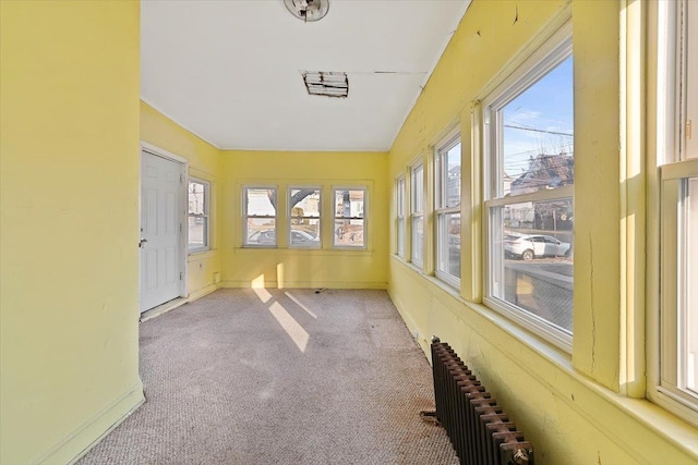 unfurnished sunroom with radiator heating unit