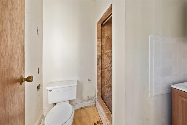 bathroom featuring vanity, hardwood / wood-style floors, walk in shower, and toilet