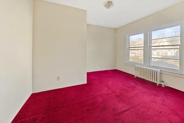 spare room with radiator and carpet flooring