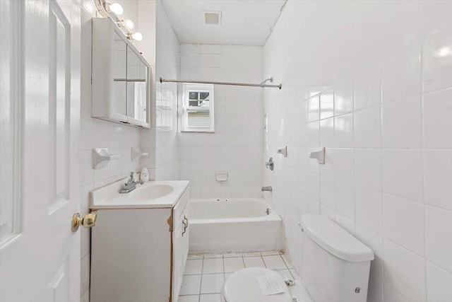 full bathroom with tile patterned floors, toilet, tile walls, vanity, and tiled shower / bath combo