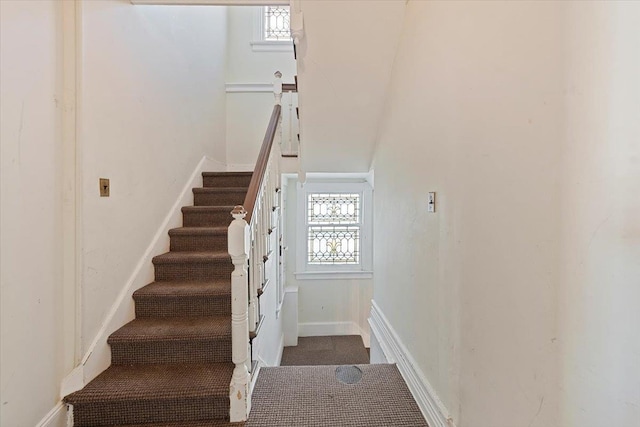 stairs with a healthy amount of sunlight and carpet floors