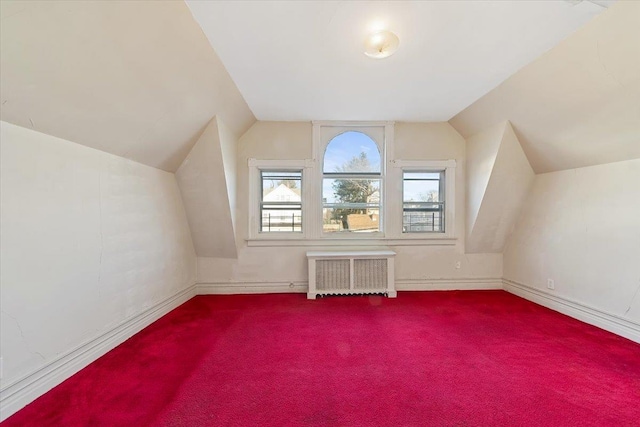 additional living space with carpet floors, radiator heating unit, and vaulted ceiling