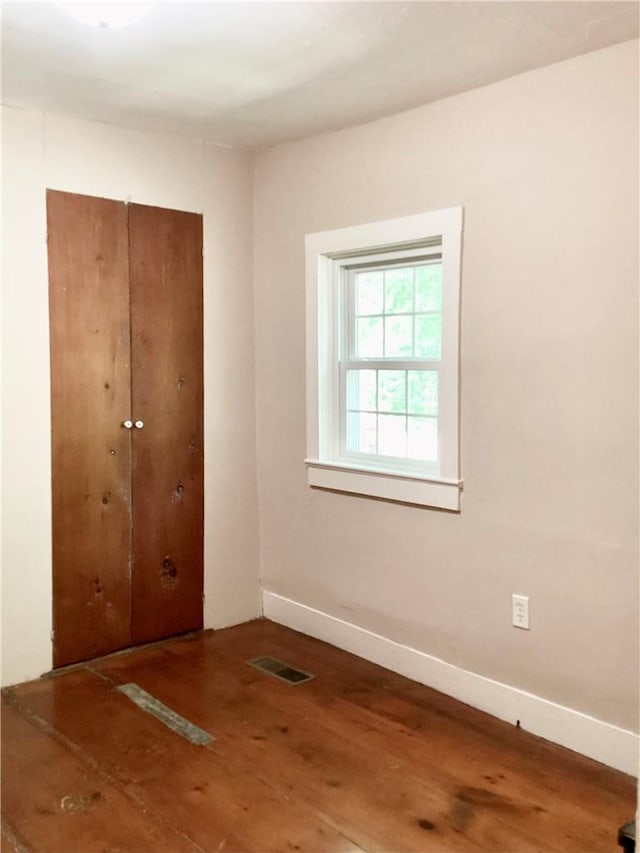 unfurnished bedroom with a closet and wood-type flooring