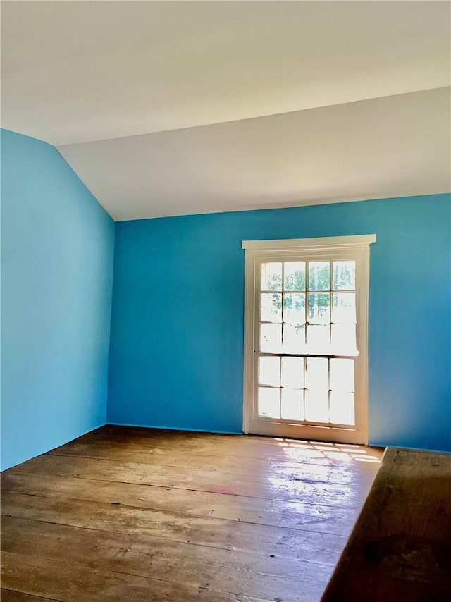 unfurnished room with wood-type flooring and vaulted ceiling