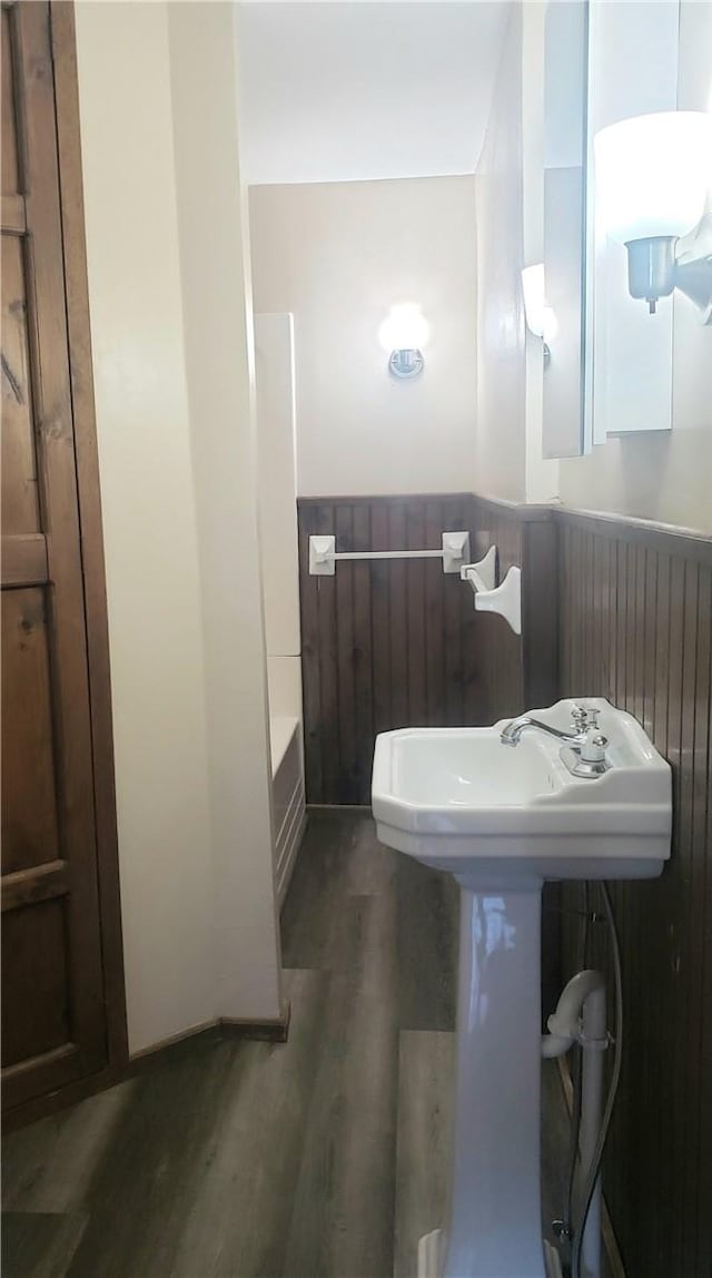 bathroom with a tub, sink, and hardwood / wood-style flooring