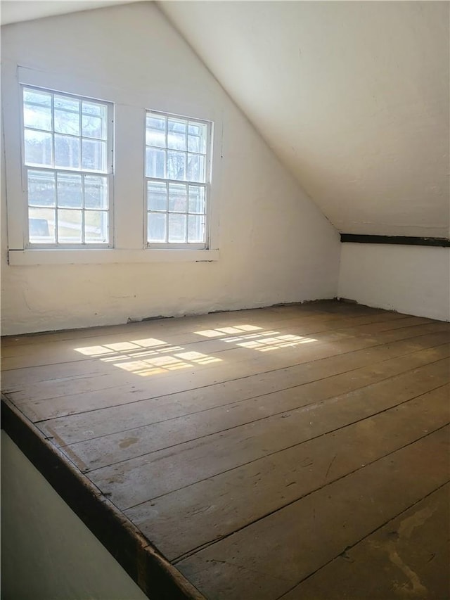 bonus room with wood-type flooring and vaulted ceiling