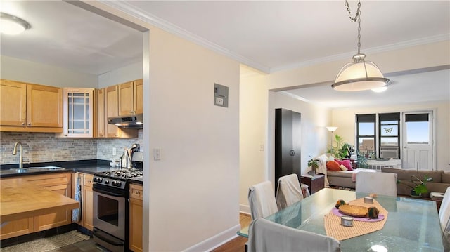 kitchen featuring backsplash, stainless steel gas range oven, dark wood-type flooring, crown molding, and sink