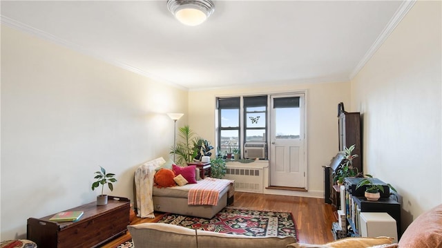 sitting room with radiator, hardwood / wood-style floors, cooling unit, and ornamental molding