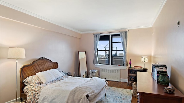 bedroom featuring radiator heating unit, cooling unit, ornamental molding, and hardwood / wood-style flooring