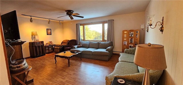 living room with hardwood / wood-style floors, track lighting, ceiling fan, and a baseboard heating unit