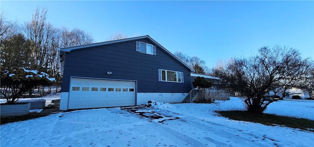 view of snow covered exterior with a garage