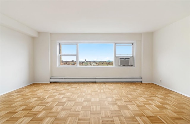 spare room featuring cooling unit, a healthy amount of sunlight, baseboard heating, and light parquet floors