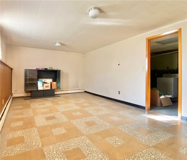 unfurnished room featuring washer / clothes dryer and a baseboard heating unit