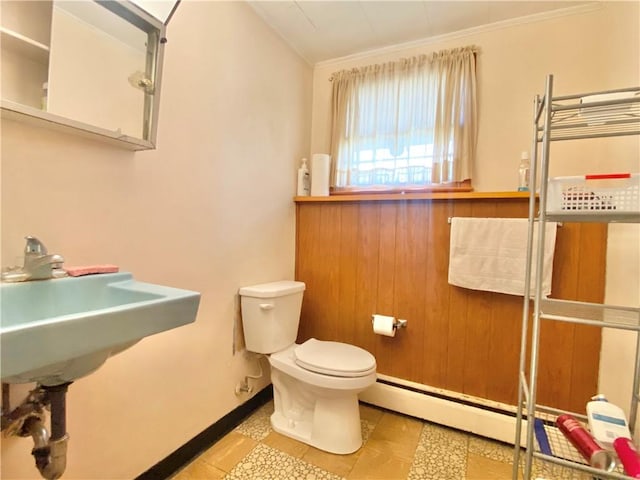 bathroom featuring baseboard heating, toilet, tile patterned flooring, and ornamental molding