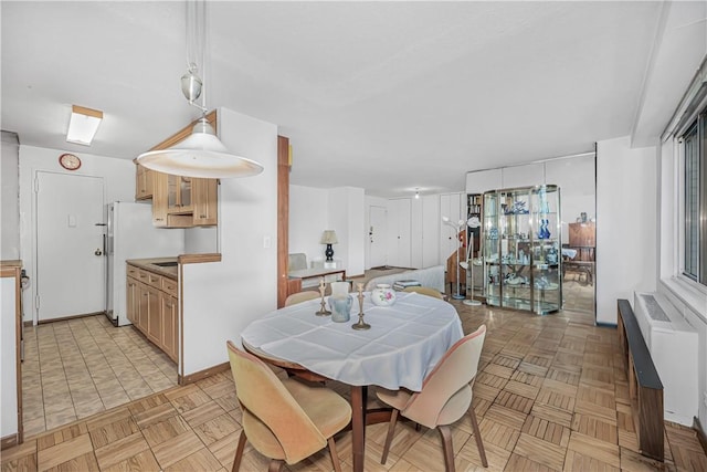 dining space featuring radiator and light parquet floors