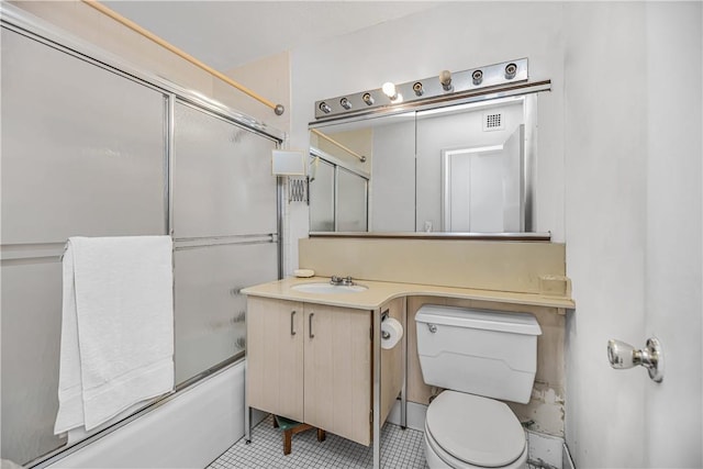 full bathroom with shower / bath combination with glass door, tile patterned flooring, vanity, and toilet