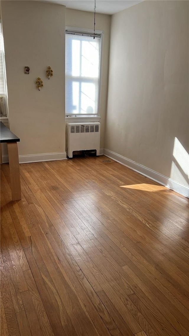 unfurnished dining area with light hardwood / wood-style floors and radiator