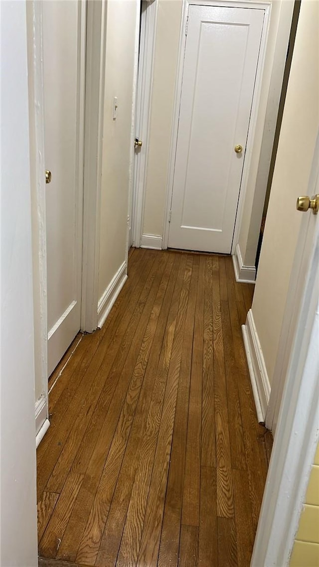 corridor with hardwood / wood-style flooring