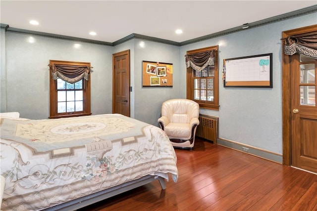 bedroom with crown molding, radiator heating unit, and dark hardwood / wood-style floors