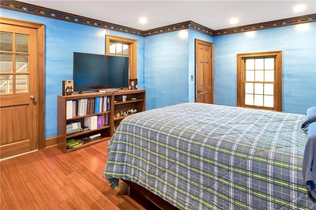 bedroom with hardwood / wood-style floors and ornamental molding