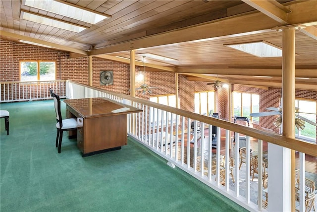 interior space with a healthy amount of sunlight, wooden ceiling, and brick wall