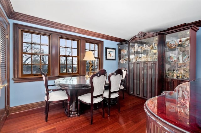 dining space featuring crown molding and dark wood-type flooring