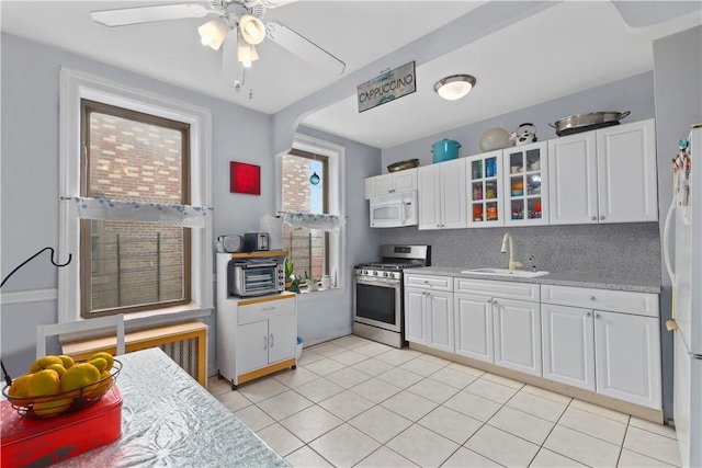 kitchen with white cabinetry, sink, ceiling fan, backsplash, and white appliances