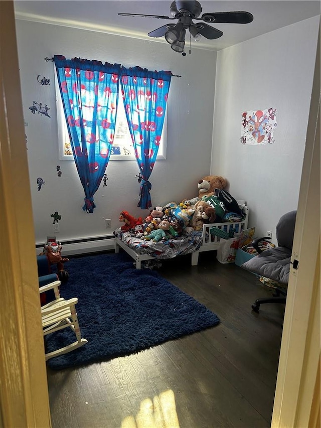 playroom featuring baseboard heating, wood finished floors, and a ceiling fan