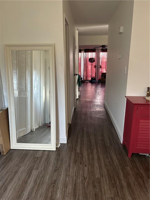 corridor with wood finished floors and baseboards