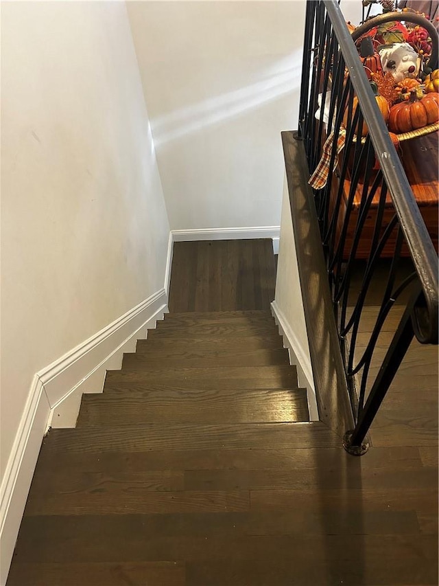 stairs with wood finished floors and baseboards